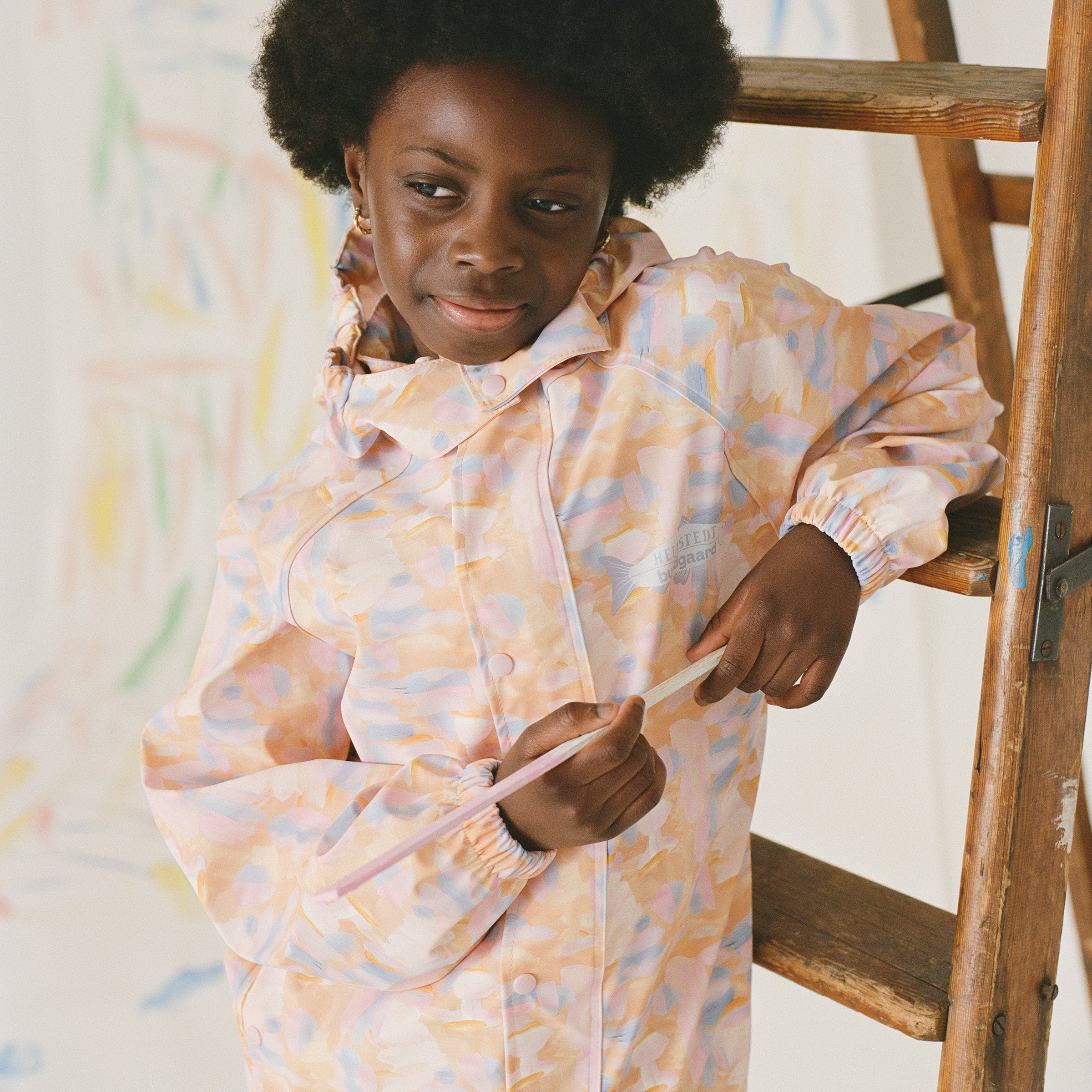Barn iført Bundgaard x Helmstedt regnjakke i pastelfarvet mønster. Stilfuld og funktionel regntøjskollektion designet til leg og bevægelse i al slags vejr.