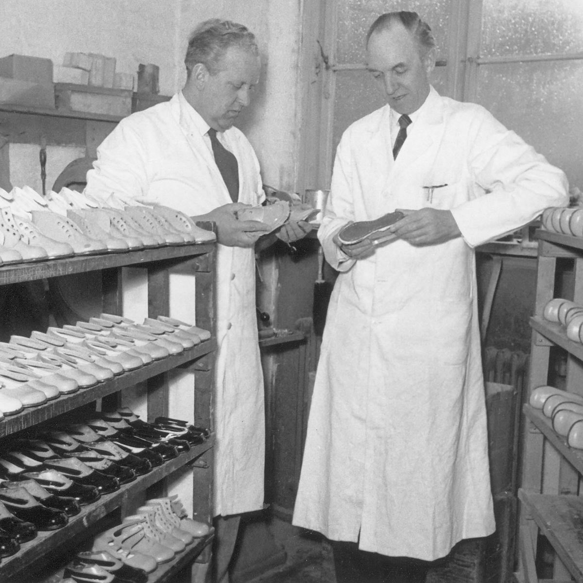 Historisk foto af Bundgaard-skomagere, der håndlaver børnesko i en dansk skofabrik – tradition og kvalitet siden 1904.