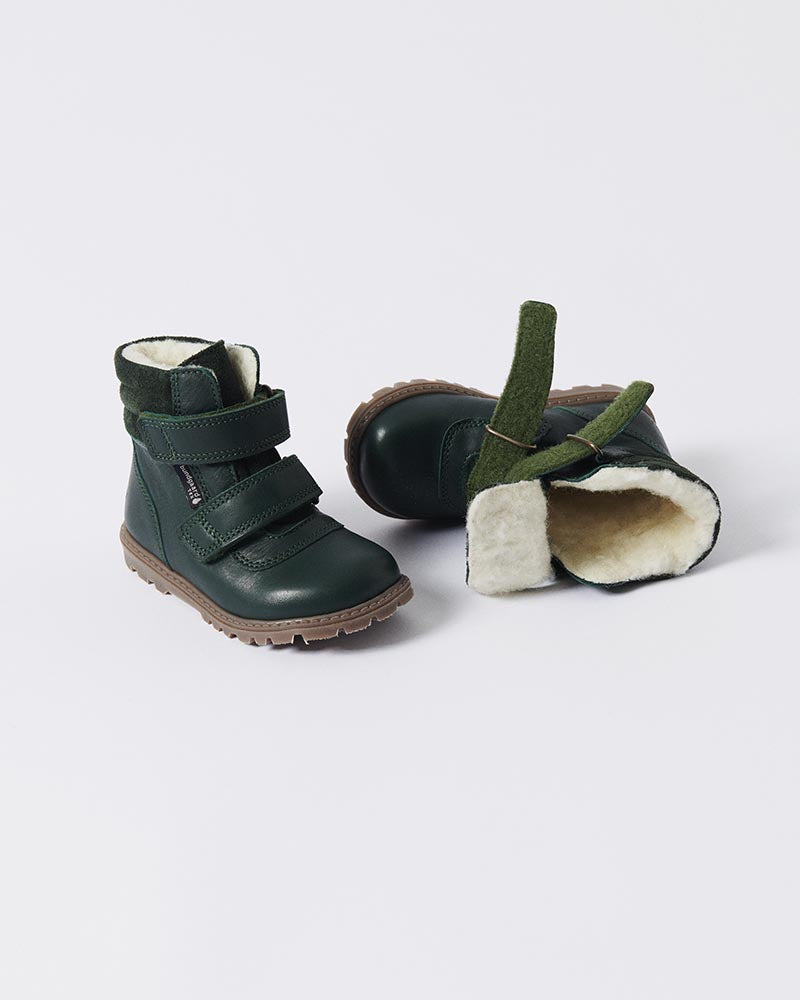 Mørkegrønne vinterstøvler til børn med blødt uldfor, robust sål og justerbare velcrolukninger. Perfekt til kolde vinterdage med maksimal komfort og varme.